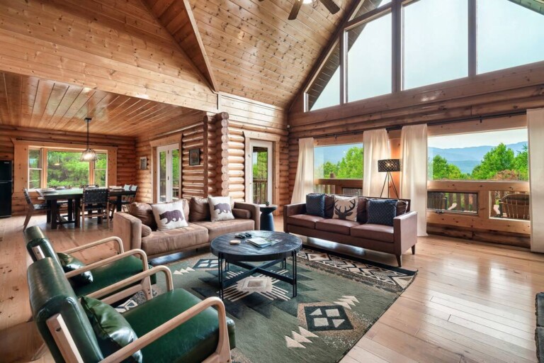 Open-plan log cabin living room with vaulted ceiling and Smoky Mountain views